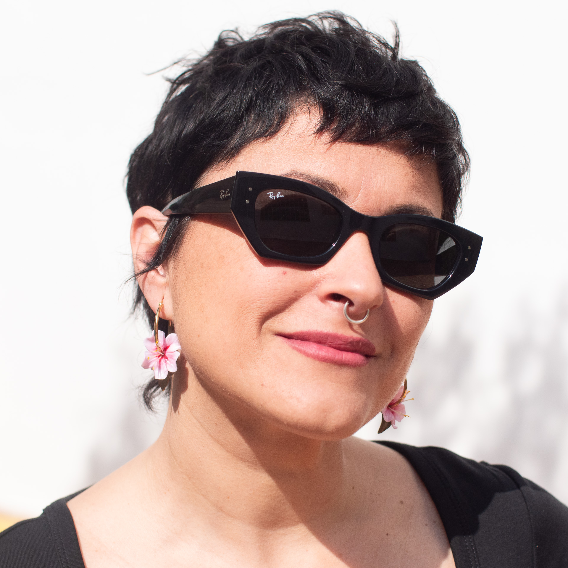 a woman wearing sunglasses and a nose ring